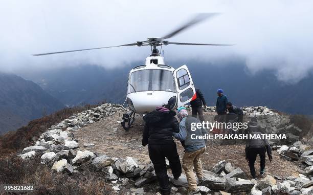 In this photograph taken on April 17 an unidentified injured person boarding a helicopter at Mong La village near Namche Bazar on the route to reach...
