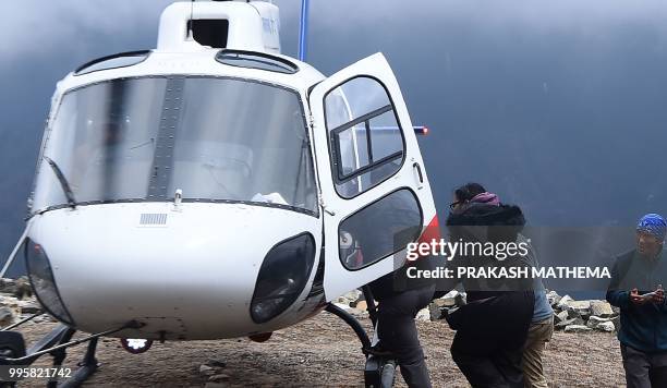 In this photograph taken on April 17 an unidentified injured person boards a helicopter at Mong La village near Namche Bazar on the route to reach...