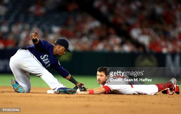 Jean Segura of the Seattle Mariners tags out Ian Kinsler of the Los Angeles Angels of Anaheim stealing second base during the fourth inning of a game...