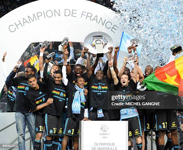 Marseille' Senegalese forward Mamadou Niang surrounded by team-mates lifts the French L1 trophy at the end of their French L1 football match...