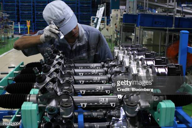 An employee inspects electric power steering gears on the production line of Jtekt Corp's Hanazono plant in Okazaki, Aichi Prefecture, Japan, on...