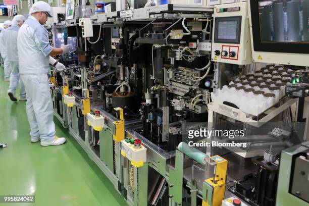 Employees assemble motor control units on the production line of Jtekt Corp's Hanazono plant in Okazaki, Aichi Prefecture, Japan, on Tuesday, July...