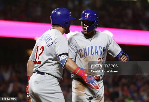 Addison Russell of the Chicago Cubs is congratulated by Kyle Schwarber after he scored in the seventh inning against the San Francisco Giants at AT&T...