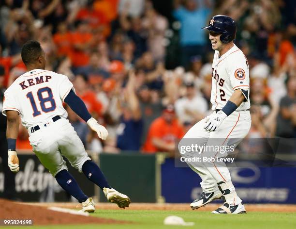 Alex Bregman of the Houston Astros and Tony Kemp celebrate after wining in the eleventh inning against the Oakland Athletics at Minute Maid Park on...
