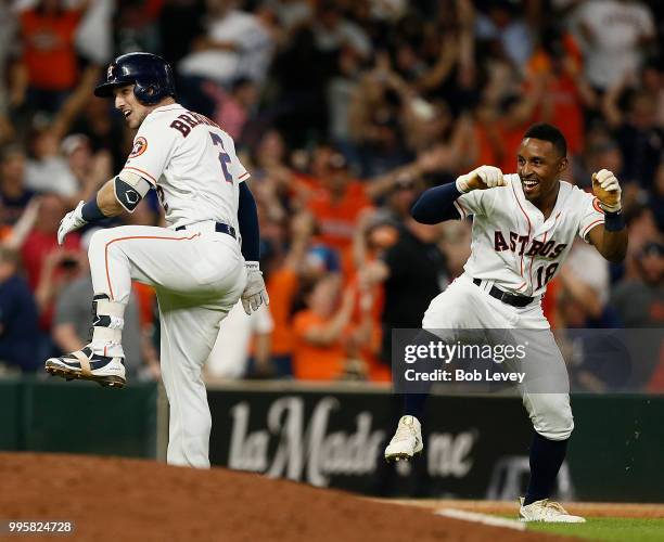 Alex Bregman of the Houston Astros and Tony Kemp celebrate after wining in the eleventh inning against the Oakland Athletics at Minute Maid Park on...