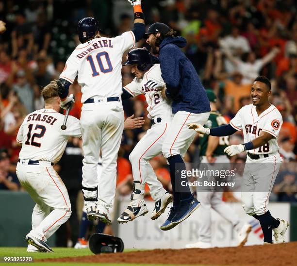 Alex Bregman of the Houston Astros celebrates with Yuli Gurriel,Jake Marisnick, Max Stassi and Tony Kemp after singling in the winning run in the...