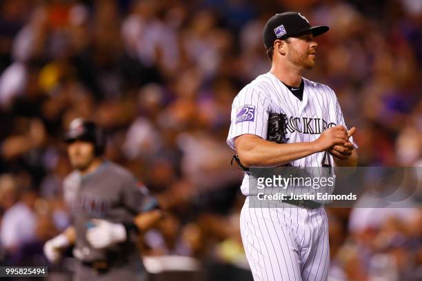 Relief pitcher Scott Oberg of the Colorado Rockies looks out to the outfield as A.J. Pollock of the Arizona Diamondbacks rounds the bases on his solo...