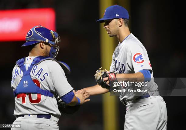 Steve Cishek of the Chicago Cubs shakes hands with Willson Contreras after they beat the San Francisco Giants at AT&T Park on July 10, 2018 in San...