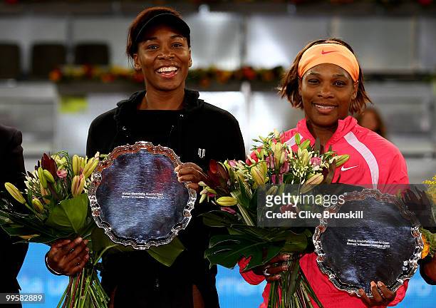 Venus Williams and Serena Williams of the USA hold their trophies after a straight sets victory against Gisela Dulko of Argentina and Flavia Pannetta...