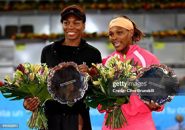 Venus Williams and Serena Williams of the USA hold their trophies after a straight sets victory against Gisela Dulko of Argentina and Flavia Pannetta...