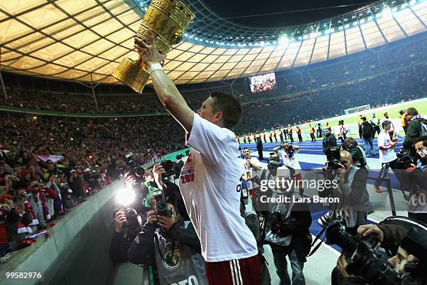 Bastian Schweinsteiger of Bayern Muenchen celebrates with the DFB Cup trophy following his team's victory at the end of the DFB Cup final match...