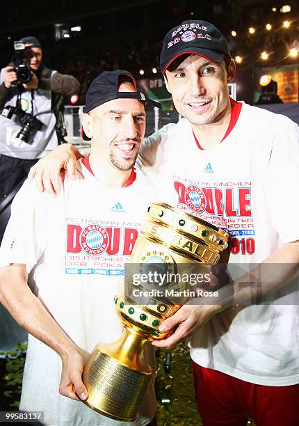 Franck Ribery and Mark van Bommel of Bayern present the trophy after winning the DFB Cup final match between SV Werder Bremen and FC Bayern Muenchen...