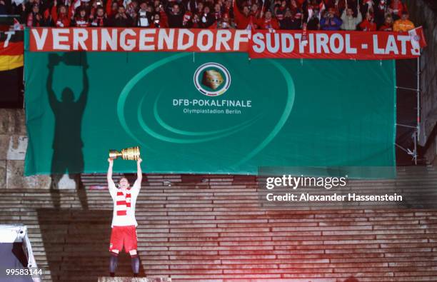 Bastian Schweinsteiger of Bayern presents the trophy after winning the DFB Cup final match between SV Werder Bremen and FC Bayern Muenchen at Olympic...