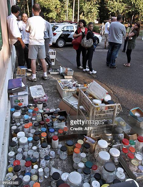 Employees of Butantan Institute stand next to jars containing spiders and scorpions that were saved from the fire that destroyed the laboratory on...
