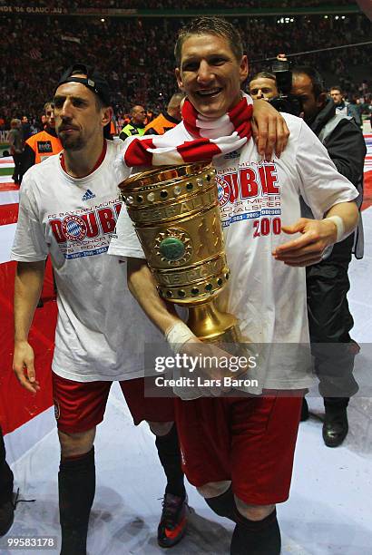 Franck Ribery and Bastian Schweinsteiger of Bayern Muenchen celebrate with the DFB Cup trophy following their team's victory at the end of the DFB...