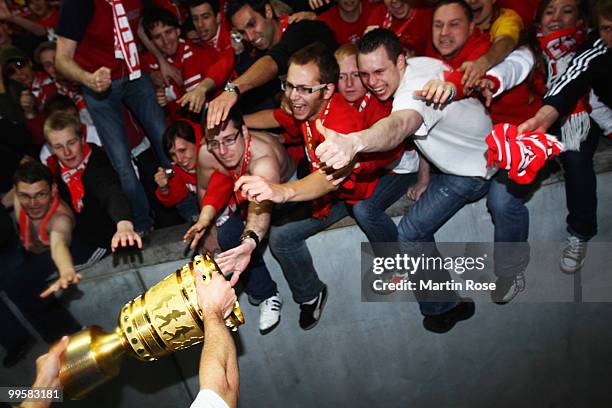 Fans try to touch the trophy after the DFB Cup final match between SV Werder Bremen and FC Bayern Muenchen at Olympic Stadium on May 15, 2010 in...