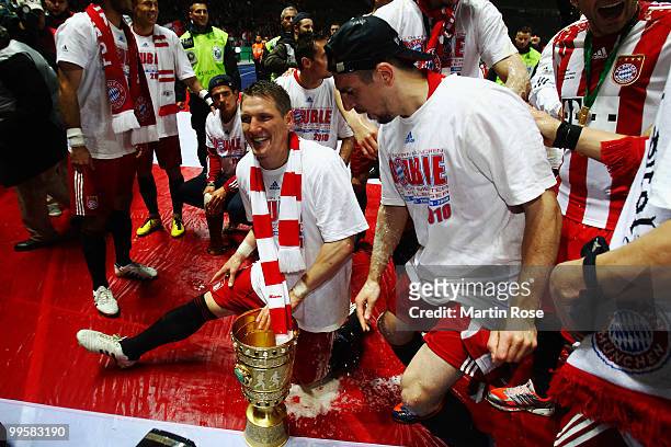 Bastian Schweinsteiger and Franck Ribery celebrate with the trophy after winning the DFB Cup final match between SV Werder Bremen and FC Bayern...