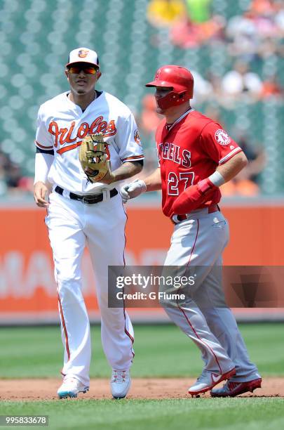 Manny Machado of the Baltimore Orioles and Mike Trout of the Los Angeles Angels run to their dugouts during the game at Oriole Park at Camden Yards...