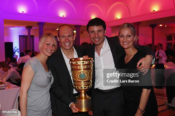 Bernadien, wife of Arjen Robben, Arjen Robben, Mark van Bommel and his wife Andra pose with the DFB Cup trophy during the Bayern Muenchen Champions...