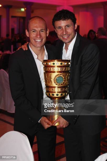Arjen Robben and Mark van Bommel pose with the DFB Cup trophy during the Bayern Muenchen Champions Party after the DFB Cup Final match against Werder...