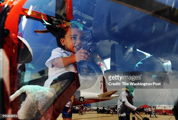 Jayden Garner from Waldorf, MD, sits in the cockpit of a US Coast Guard HH-65 Dolphin helicopter and pretends to be a pilot as other displays are...