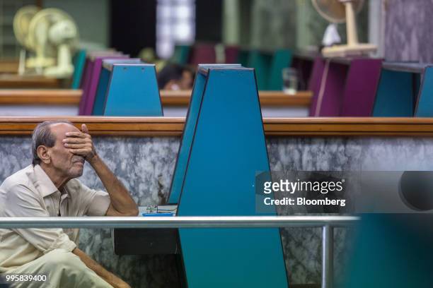 Man reacts during a trading session at the Pakistan Stock Exchange in Karachi, Pakistan, on Monday, July 9, 2018. The Pakistan economy is in...