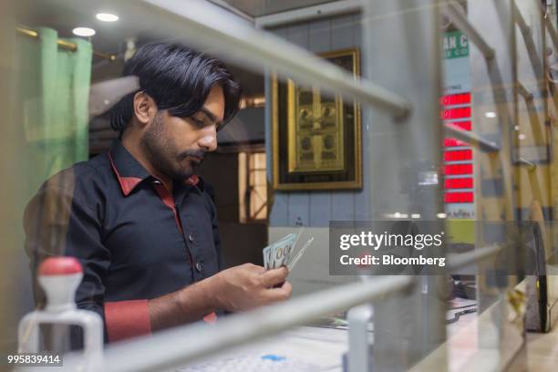 Teller counts U.S. Hundred dollar bills inside a currency exchange store in Karachi, Pakistan, on Monday, July 9, 2018. The Pakistan economy is in...