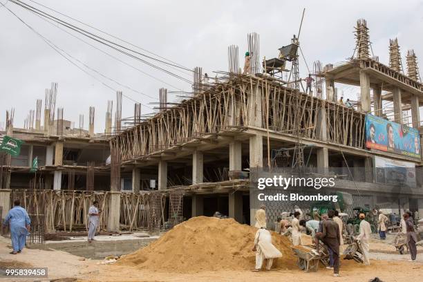 Workers labor at a construction site in Karachi, Pakistan, on Monday, July 9, 2018. The Pakistan economy is in distress. How else to describe an...