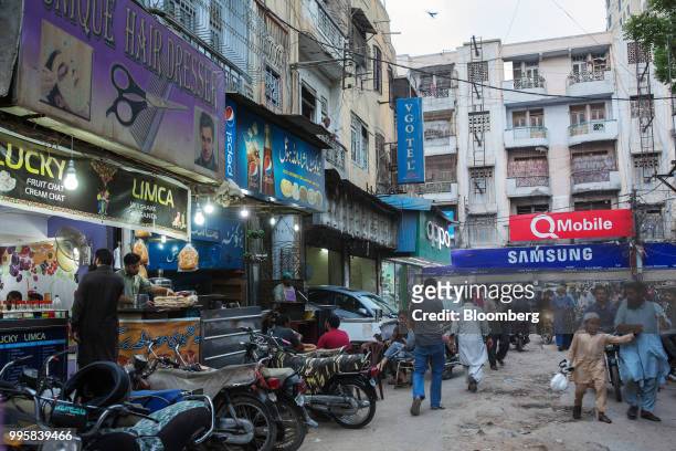 Pedestrians walk past a food stall at the Karachi Mobile Market in Karachi, Pakistan, on Monday, July 9, 2018. The Pakistan economy is in distress....