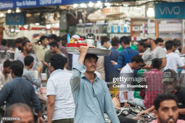 Street vendor carries snacks for sale on his head at the Karachi Mobile Market in Karachi, Pakistan, on Monday, July 9, 2018. The Pakistan economy is...