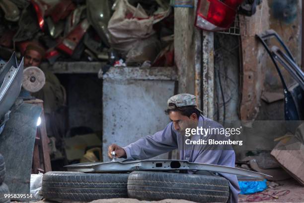 Mechanic mends a car door at a workshop in Karachi, Pakistan, on Monday, July 9, 2018. The Pakistan economy is in distress. How else to describe an...
