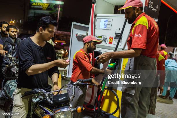 Customer pays after refueling his motorcycle at a Shell Pakistan Ltd. Gas station in Karachi, Pakistan, on Monday, July 9, 2018. The Pakistan economy...