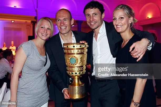 Bernadien and Arjen Robben as well as Mark van Bommel and his wife Andra pose with the trophy the Bayern Muenchen Champions Party after the DFB Cup...