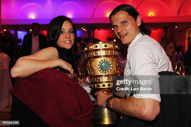 Daniel van Buyten and his girlfriend Celine pose with the DFB Cup trophy during the Bayern Muenchen Champions Party after the DFB Cup Final match...