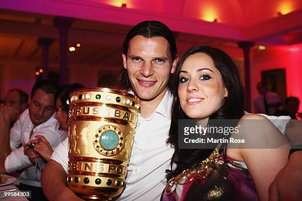Daniel van Buyten and his girlfriend Celine pose with the DFB Cup trophy during the Bayern Muenchen Champions Party after the DFB Cup Final match...
