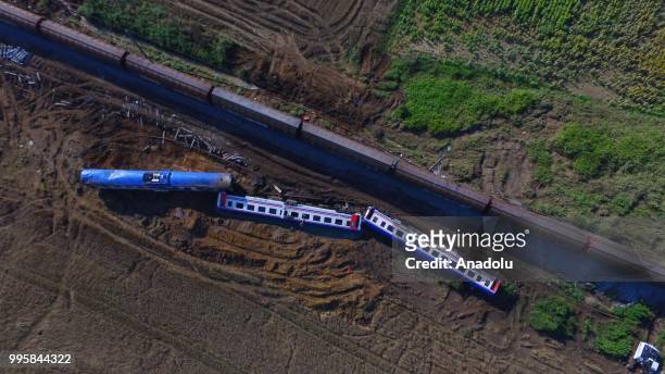 An aerial view of a passenger train on the repaired railway passing three of five derailed carriages, which await removal, after the accident at the...
