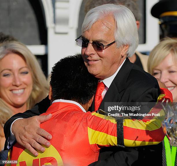 Jockey Martin Garcia and Trainer Bob Baffert embrace in the winners circle after Lookin At Lucky won the 135th running of the Preakness Stakes at...