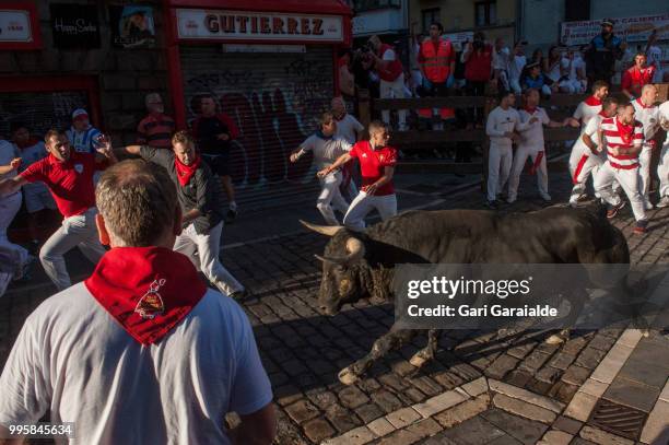 Revellers run with Nunez del Cubillo's fighting bulls during the sixth day of the San Fermin Running of the Bulls festival on July 11, 2018 in...