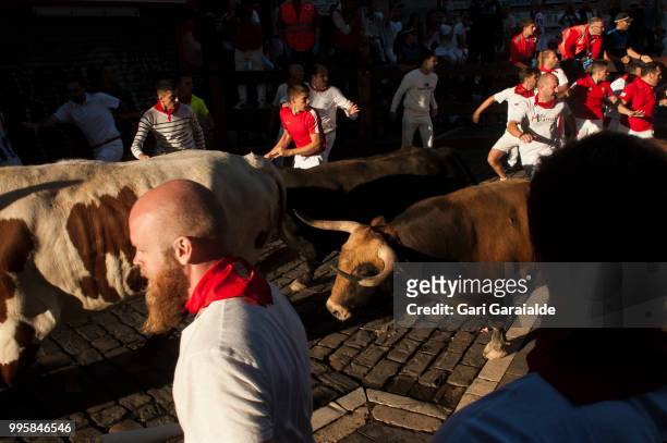 Revellers run with Nunez del Cubillo's fighting bulls during the sixth day of the San Fermin Running of the Bulls festival on July 11, 2018 in...
