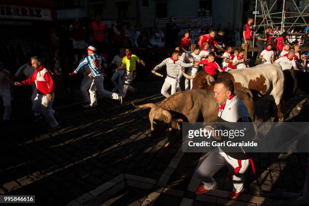 Revellers run with Nunez del Cubillo's fighting bulls during the sixth day of the San Fermin Running of the Bulls festival on July 11, 2018 in...