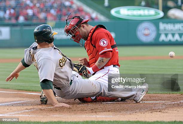 Cliff Pennington of the Oakland Athletics knocks the ball out of the glove of Mike Napoli of the Los Angeles Angels to score a run during the first...