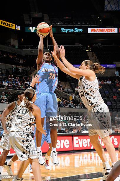 Sancho Lyttle of the Atlanta Dream shoots against Ruth Riley and Becky Hammon of the Silver Stars during the game at AT&T Center on May 15, 2010 in...
