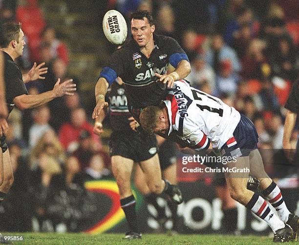 Matt Adamson of the Panthers gets a pass away while being tackled by Michael Crocker of the Roosters during the NRL round 20 match betwen the Penrith...