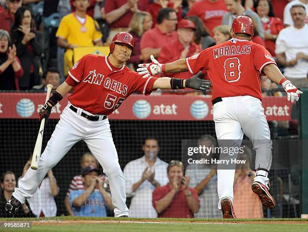 Hideki Matsui of the Los Angeles Angels gives Kendry Morales a handshake after his three run homerun for a 3-2 lead over the Oakland Athletics during...