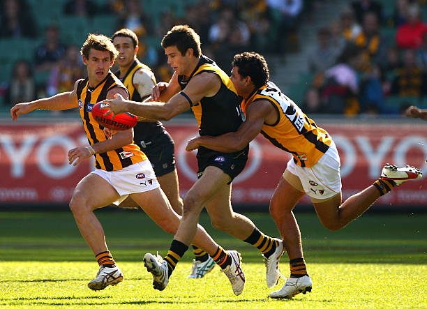 Trent Cotchin of the Tigers is tackled by Cyril Rioli of the Hawks during the round eight AFL match between the Richmond Tigers and the Hawthorn...