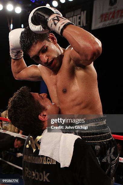 Amir Khan of Great Britain celebrates with a trainer after defeating Paulie Malignaggi by TKO in the 11th round of his WBA light welterweight title...