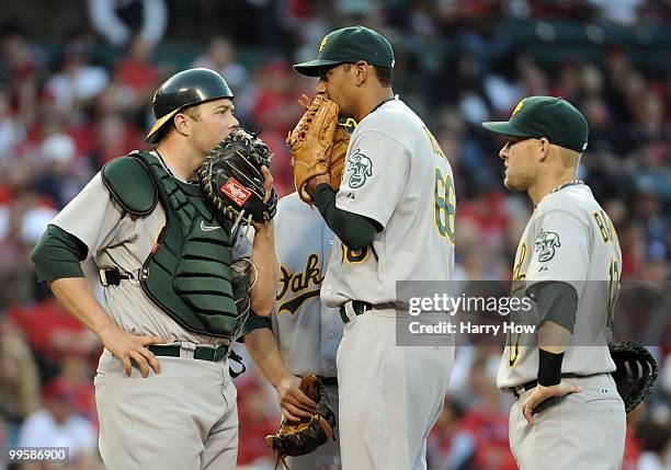 Tyson Ross, Landon Powell and Daric Barton of the Oakland Athletics meet at the mound in the game against the Los Angeles Angels during the fourth...