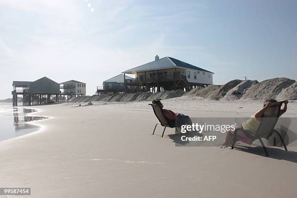 Joyce Smith and Janene Booth, tourists from Tennessee, sunbathe on a beach of Dauphin Island, a bird sanctuary in Alabama. Because of the oil spill,...