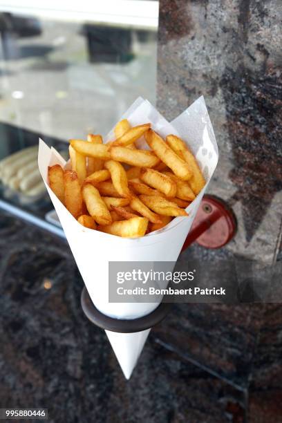 potatoes fries in a little white paper bag hanging at the wall f - patrick wall stock pictures, royalty-free photos & images