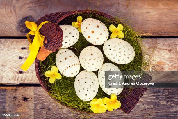 beautiful unique easter eggs in a basket, on wooden background - eggs in basket stock pictures, royalty-free photos & images